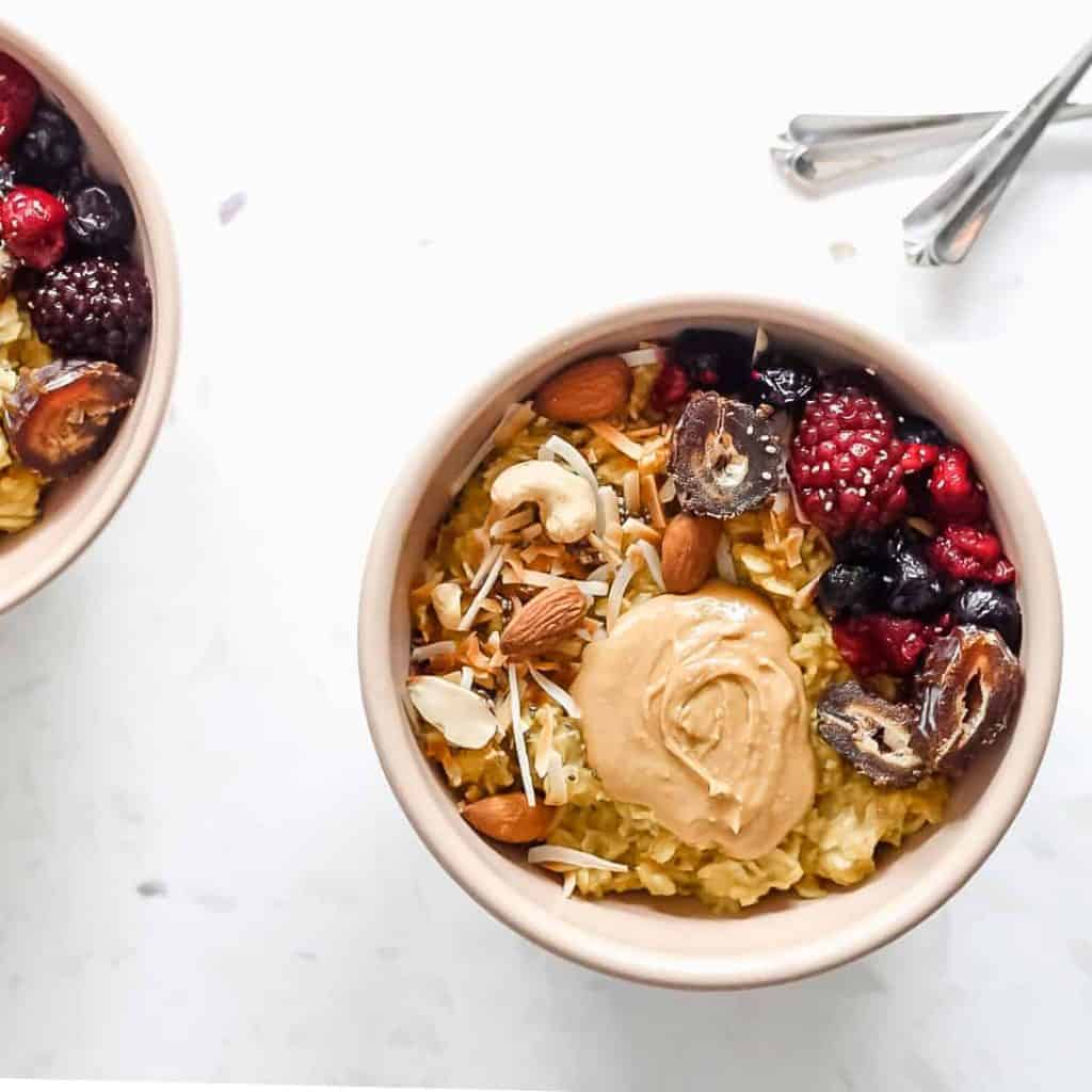 A bowl of oatmeal topped with fresh berries and nut butter.