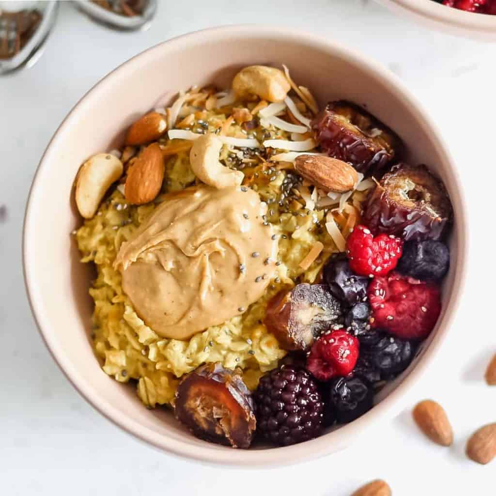 A bowl of oatmeal topped with fresh berries and nut butter