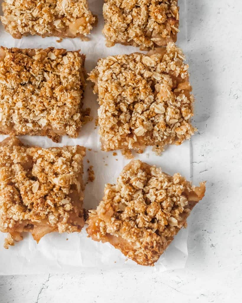 6 healthy apple crisp bars next to each other on parchment paper