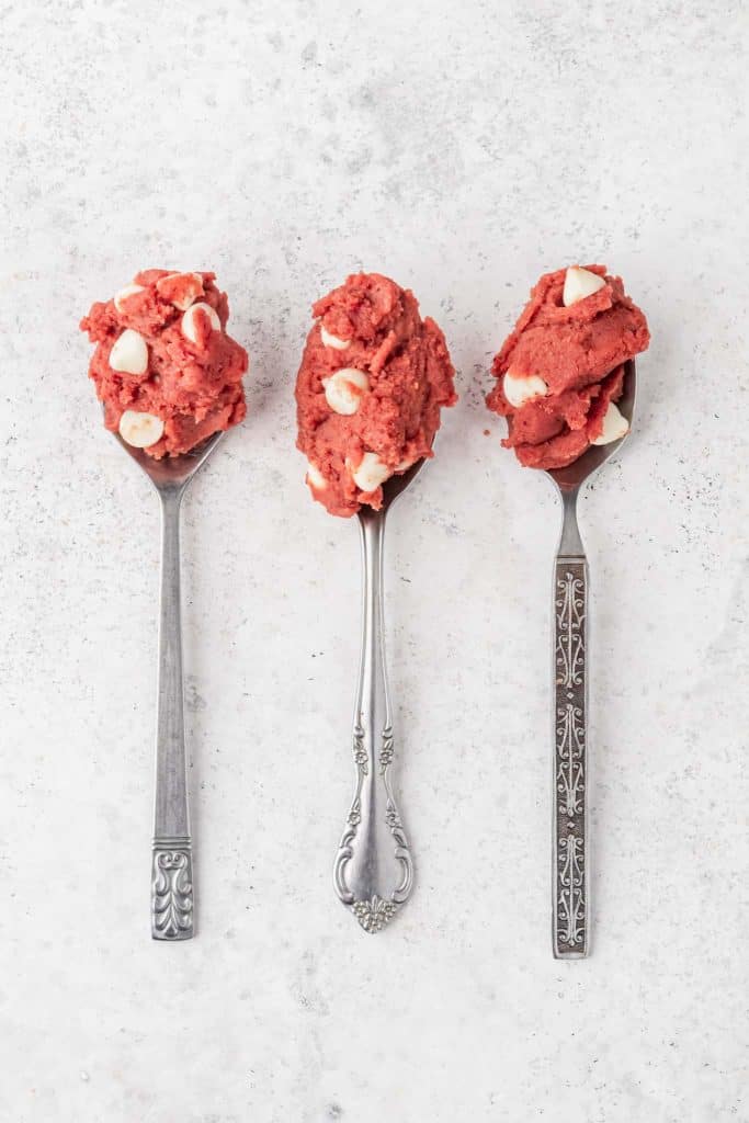 Three spoons with red velvet cookie dough