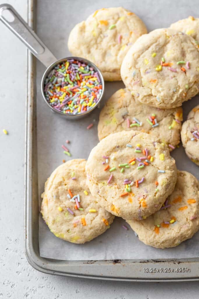 Cookies on a baking sheet with sprinkles.