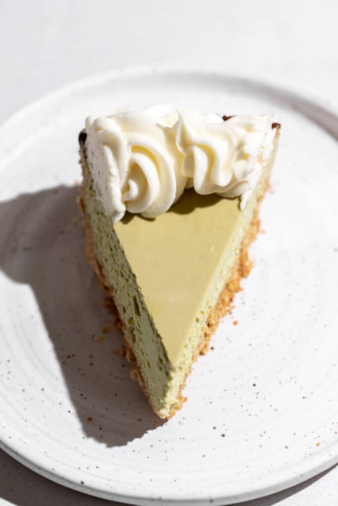 A slice of green tea cheesecake on a plate.