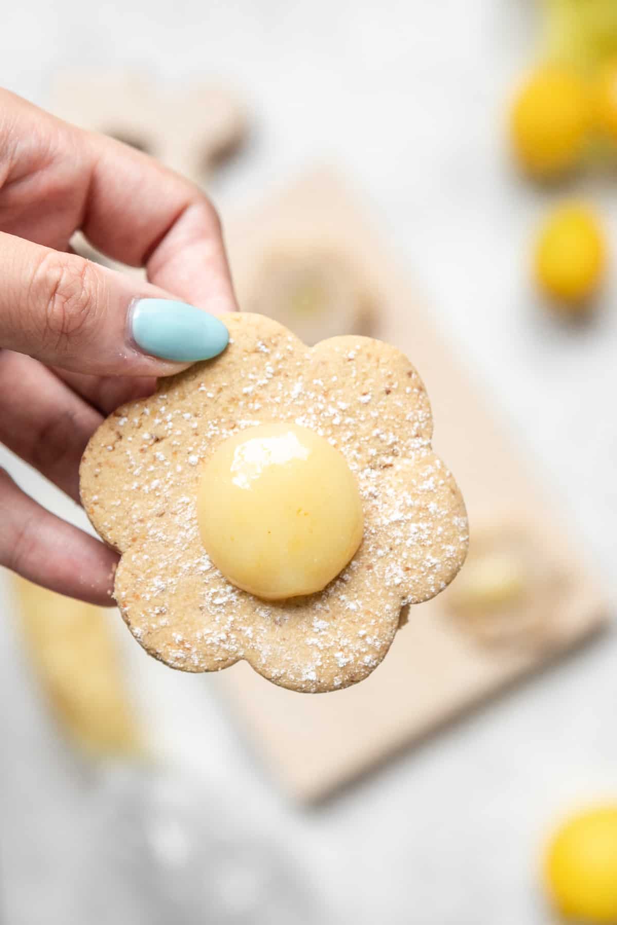 A flower shaped shortbread cookie with lemon curd in the center.