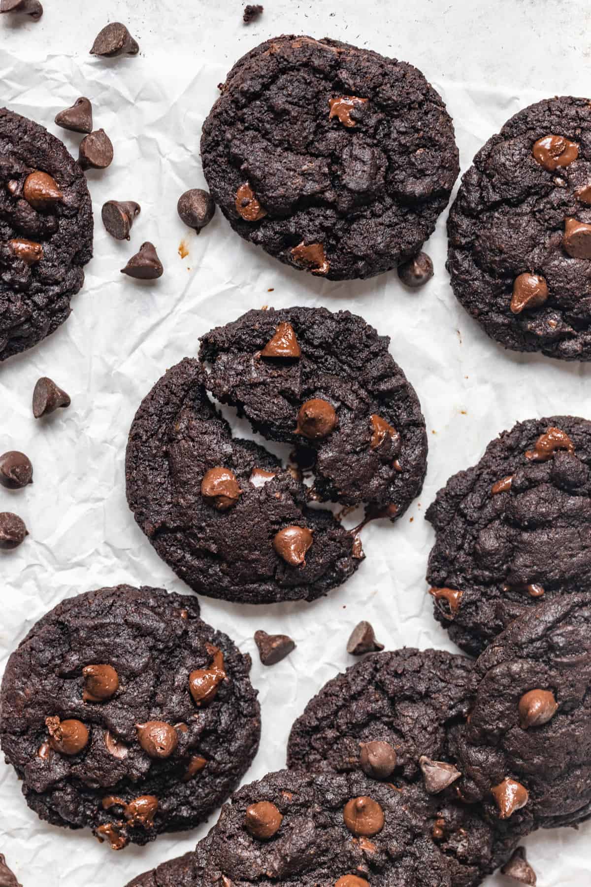 Eggless double chocolate cookies on parchment paper with one split open.