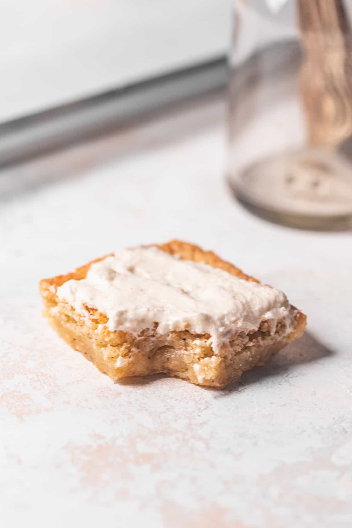 A frosted blondie with a bite taken out of it.
