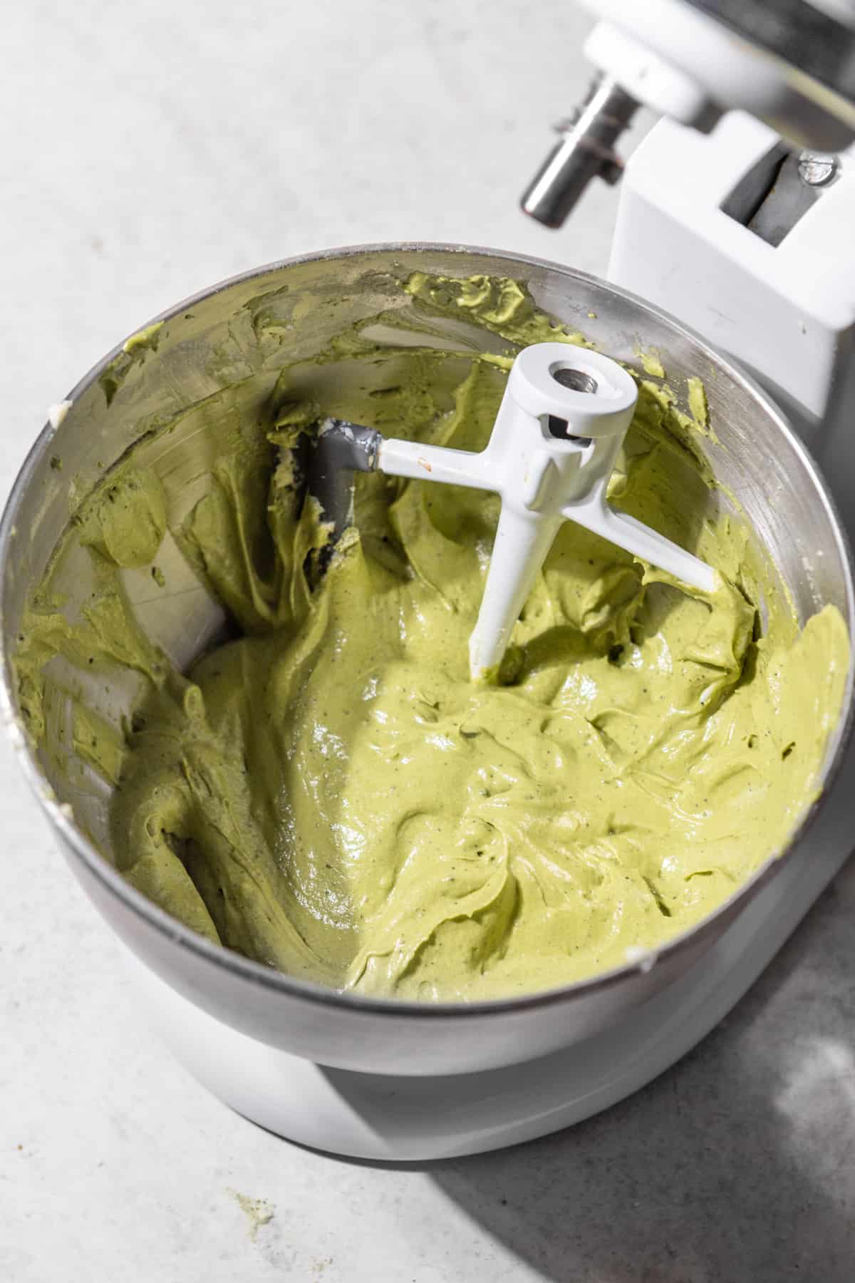 Matcha cake batter in the bowl of a stand mixer.