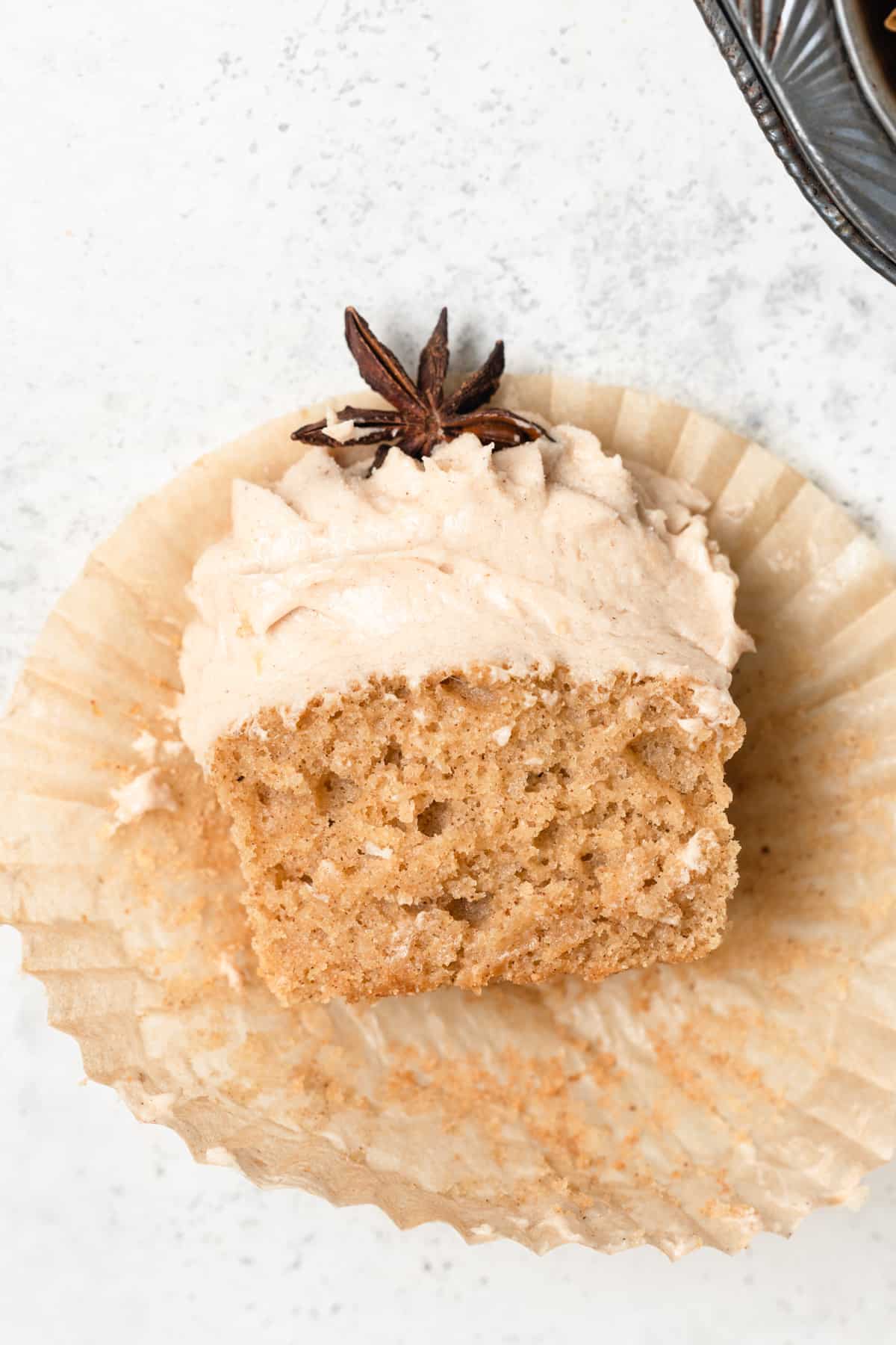 A cupcake topped with star anise cut in half to show texture.