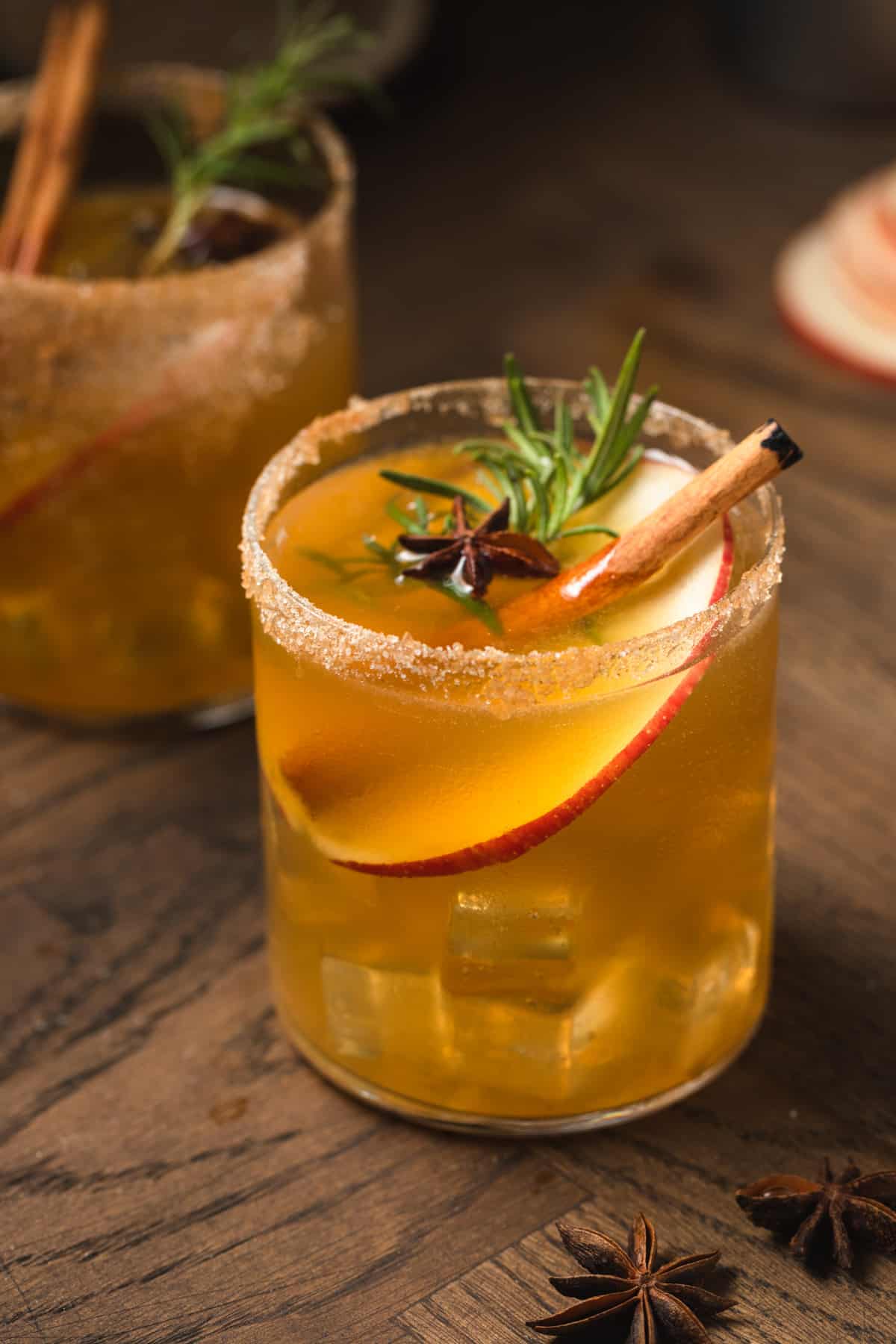 An apple cider gin margarita garnished in a glass on a wood surface.