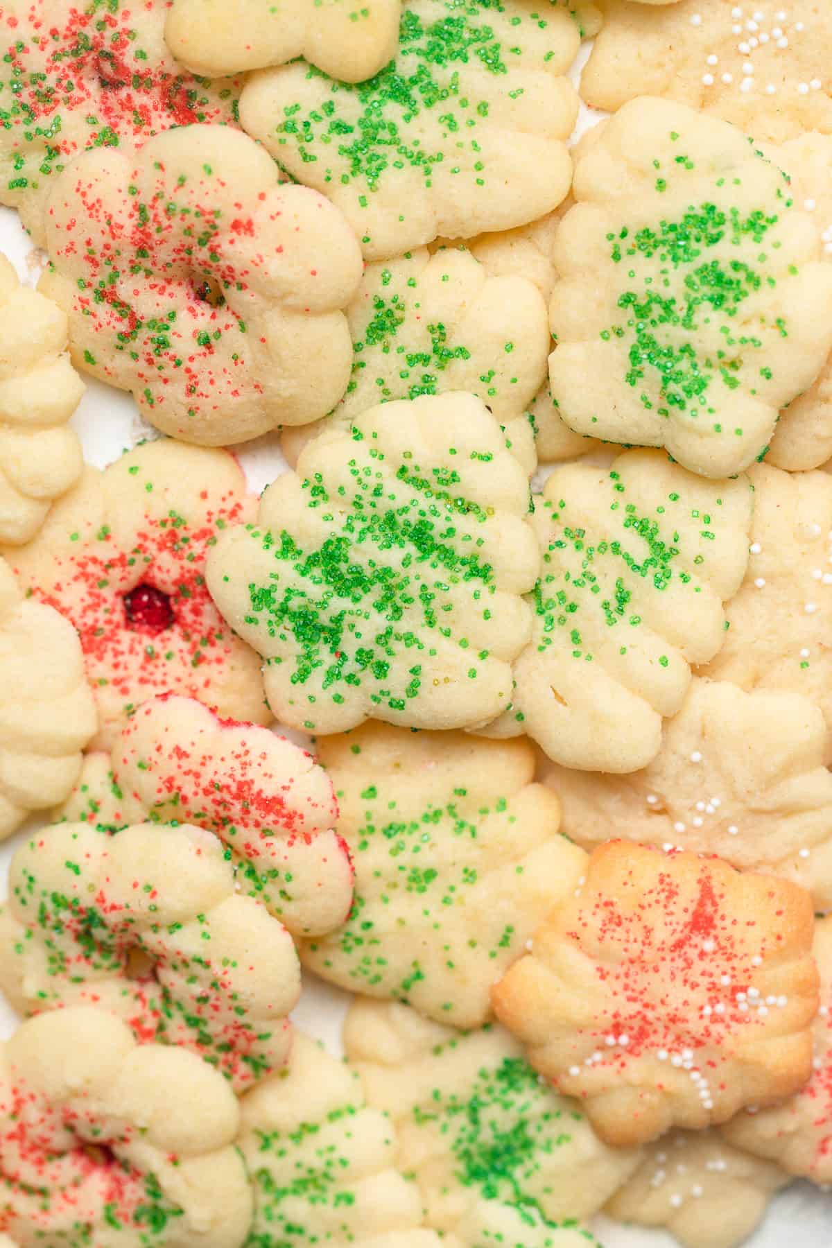 Almond spritz cookies shaped as Christmas trees, wreaths, and snowflakes.