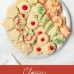 Spritz cookies decorated for Christmas on a white platter.