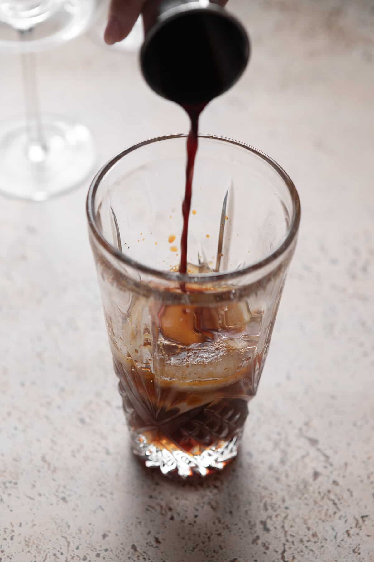 Pouring espresso into a cocktail shaker.