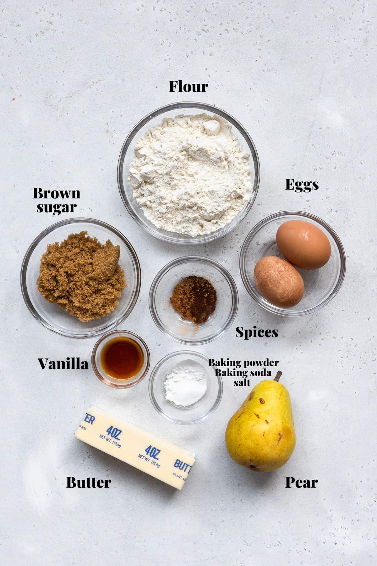 Ingredients to make vanilla pear bread with text labelling each ingredient on a white background.