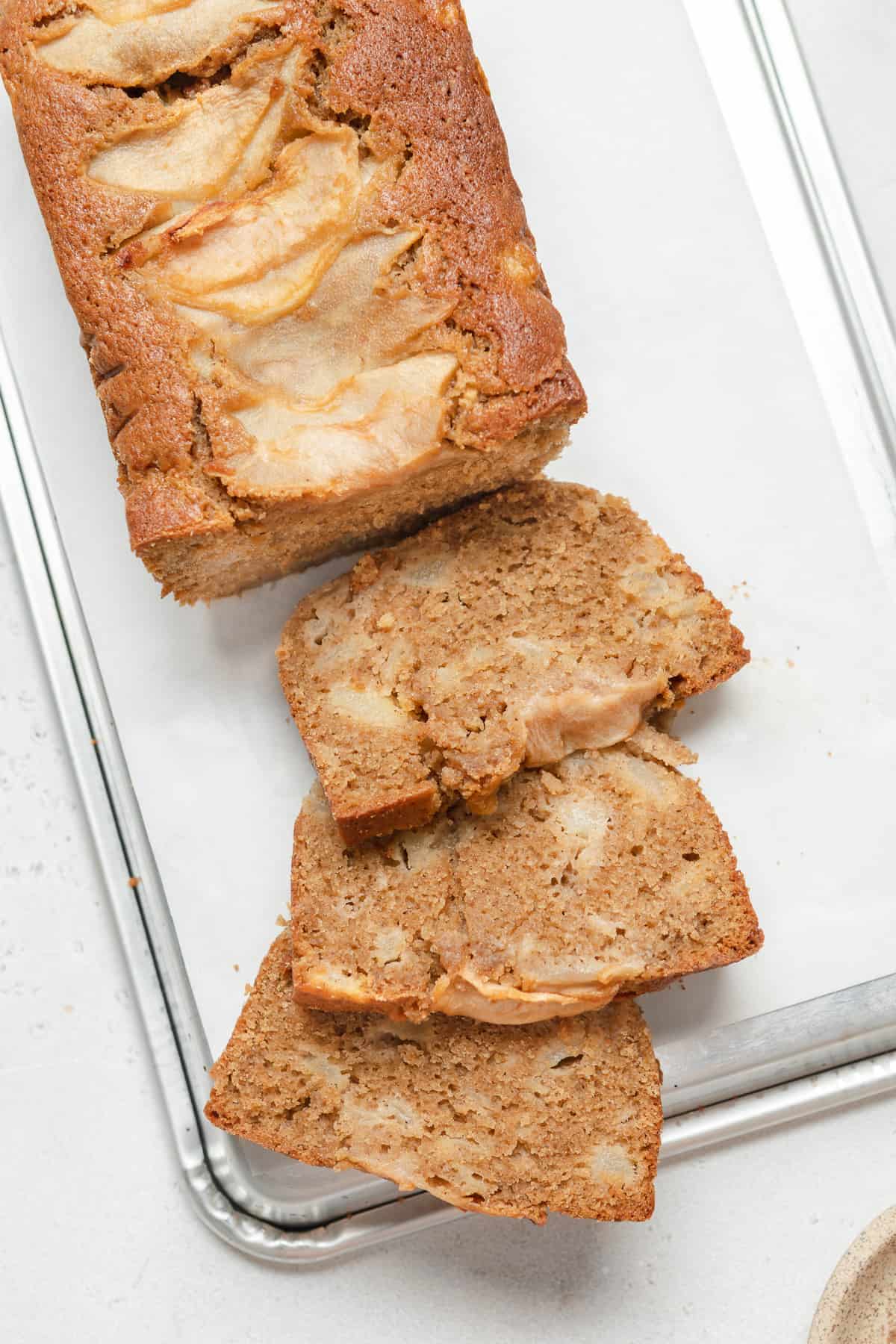 Three slices of pear bread on an upside down baking sheet.