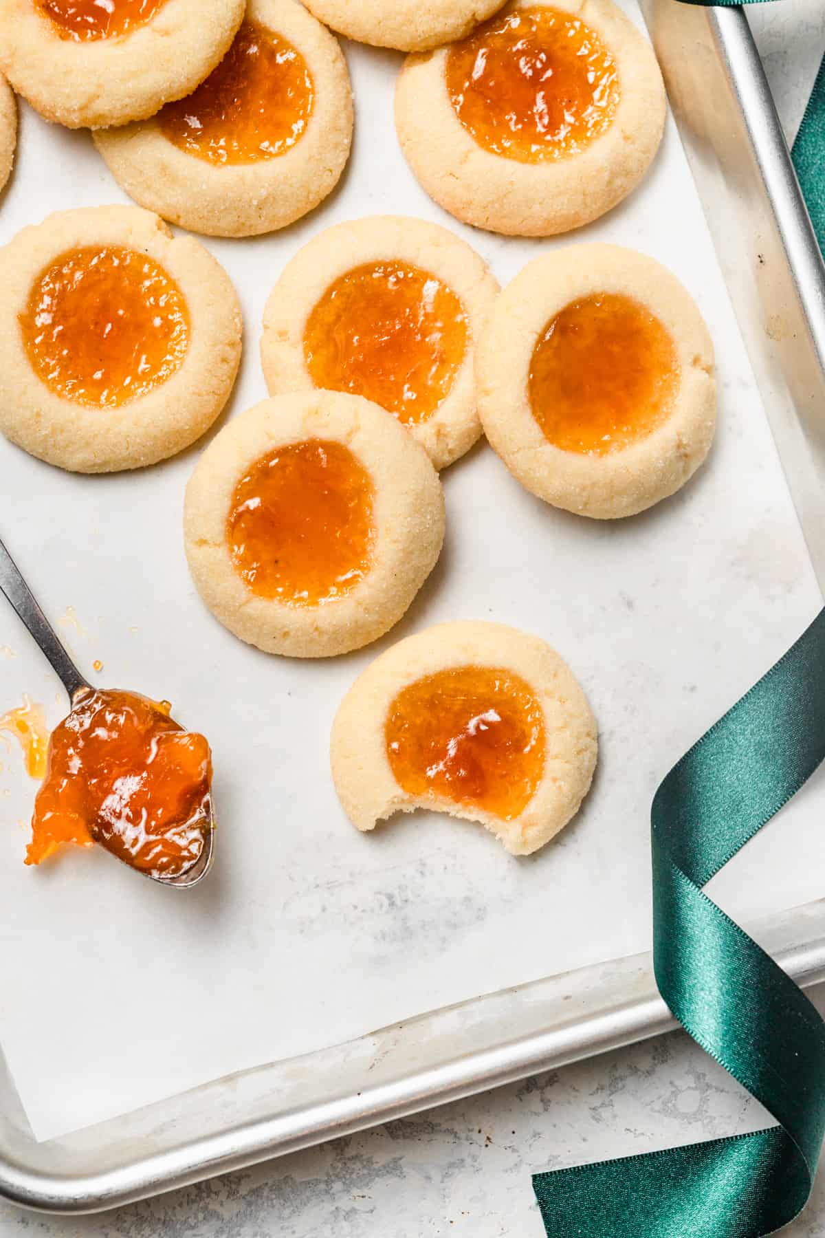 Apricot thumbprint cookies on a baking sheet.