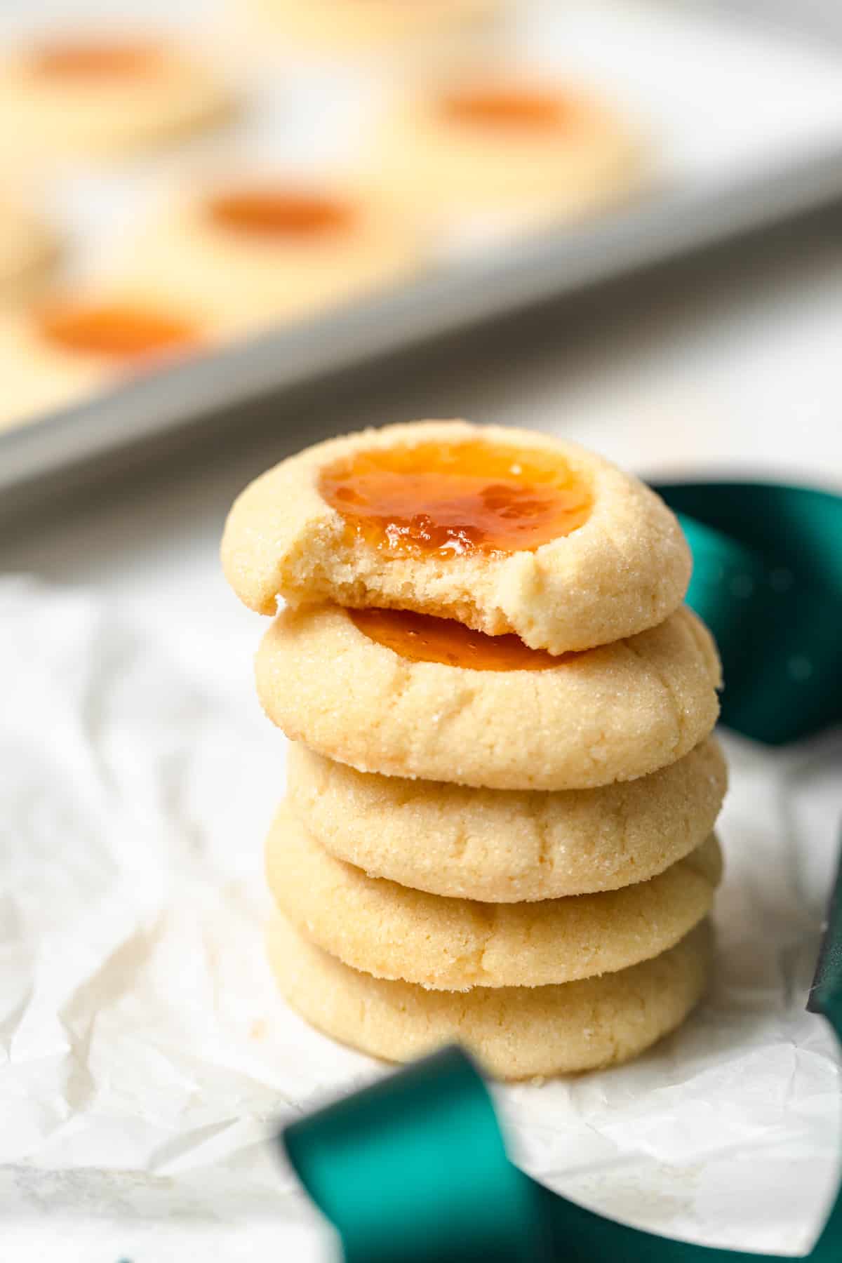 A stack of apricot cookies on parchment paper.