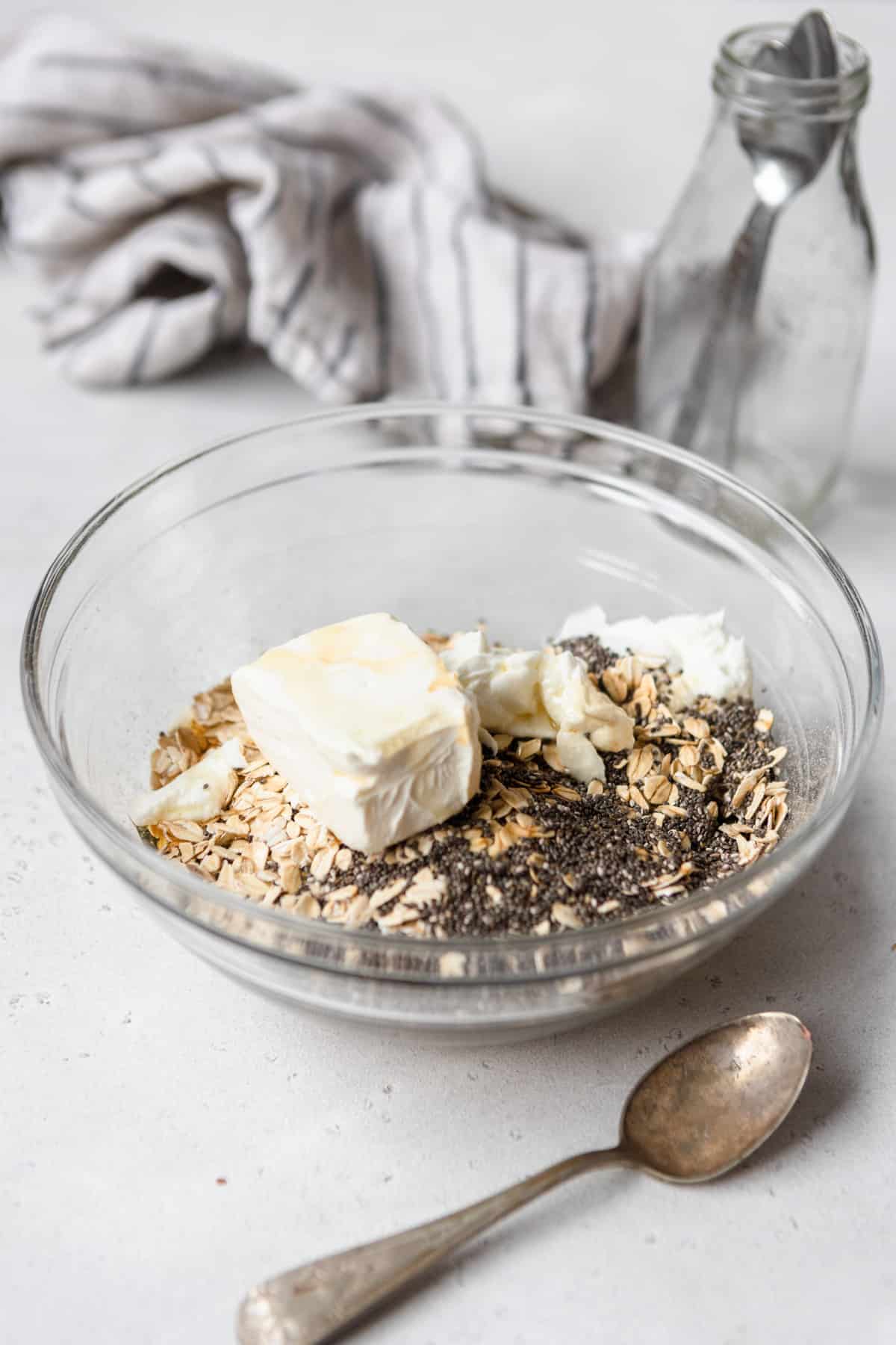 Ingredients to make cheesecake overnight oats in a bowl.