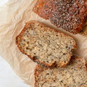 A chia seed banana bread slice on parchment paper.