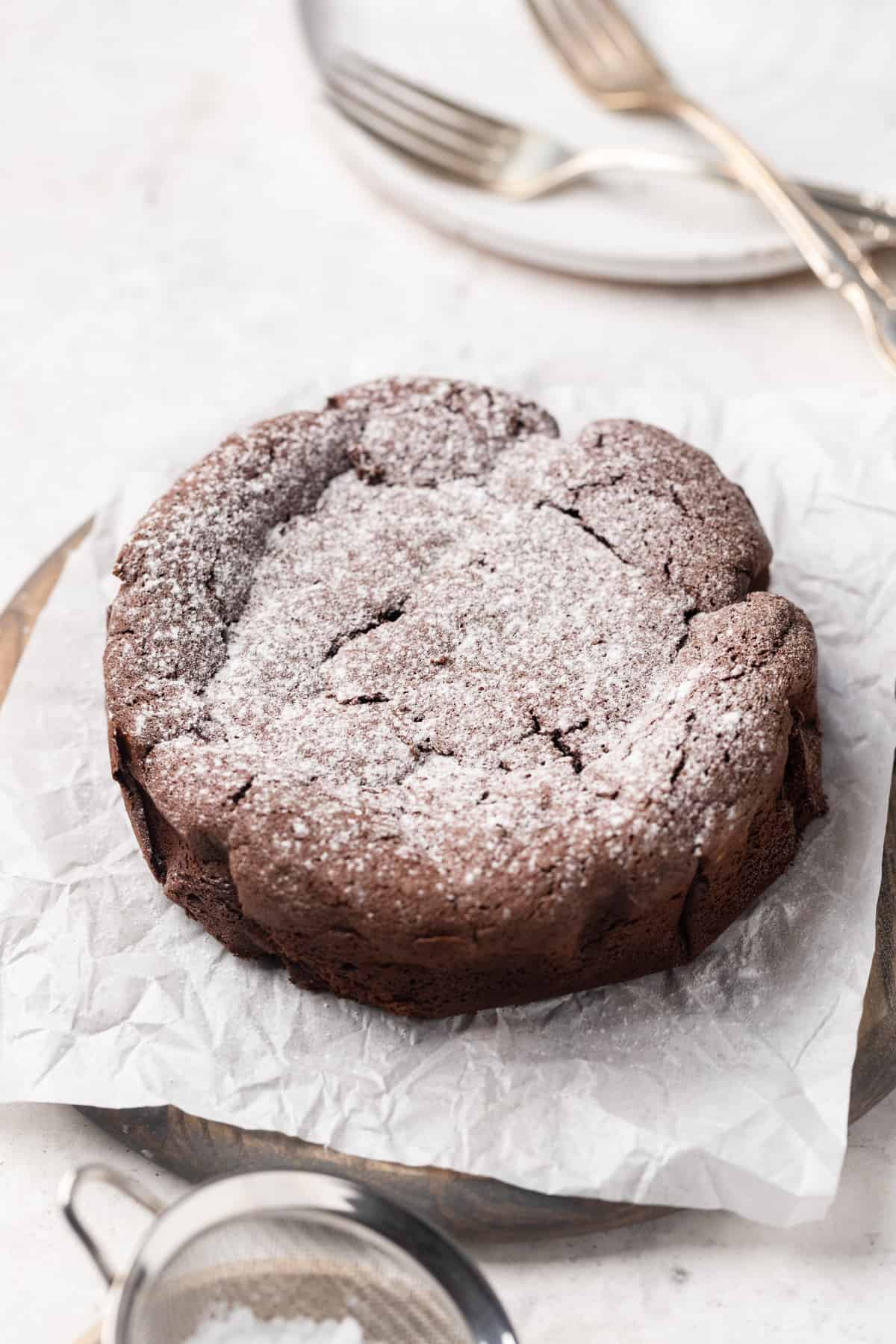 A mini flourless chocolate cake with powdered sugar.