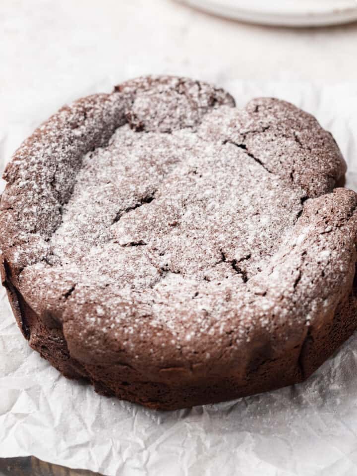 A mini flourless chocolate cake dusted with powdered sugar.