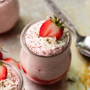 A cup of fresh strawberry mousse garnished with a strawberry slice.