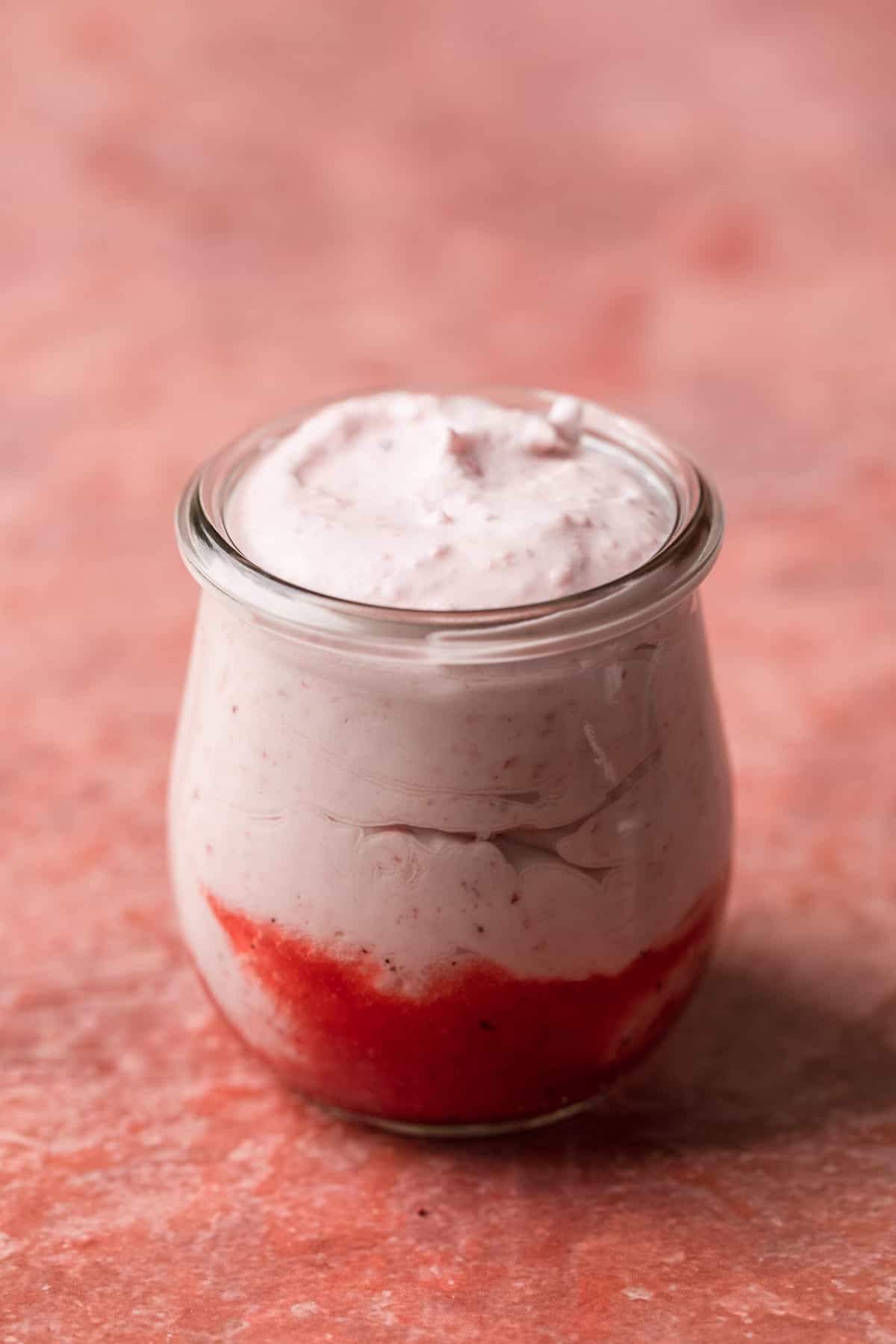 Mousse and jam layered in a jar.