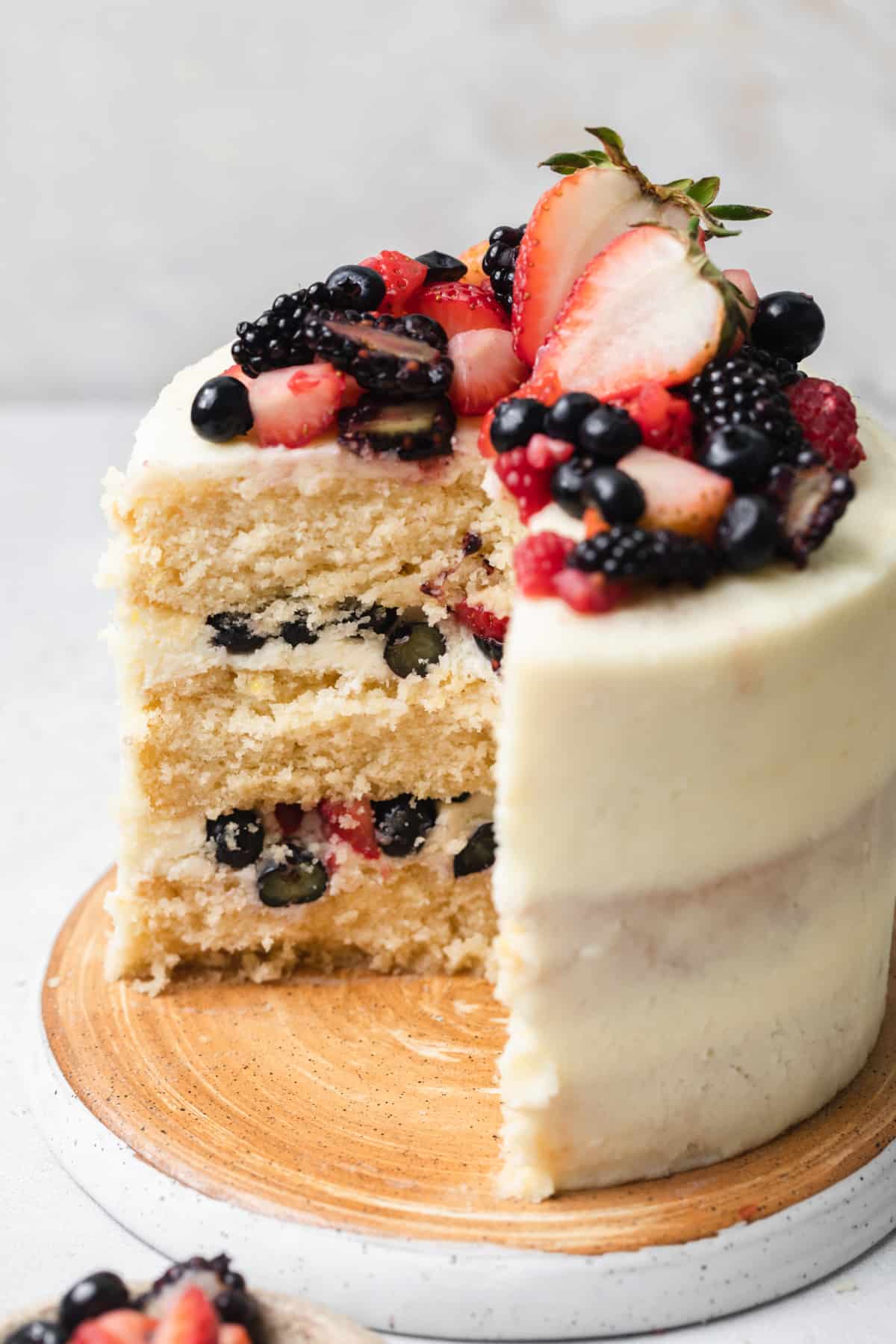 A cake topped with berries cut open to show texture.