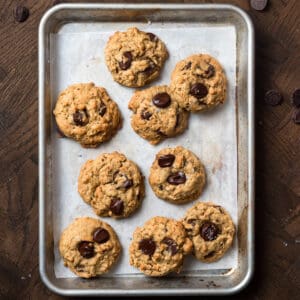 Oatmeal chocolate chip cookies on a sheet pan.