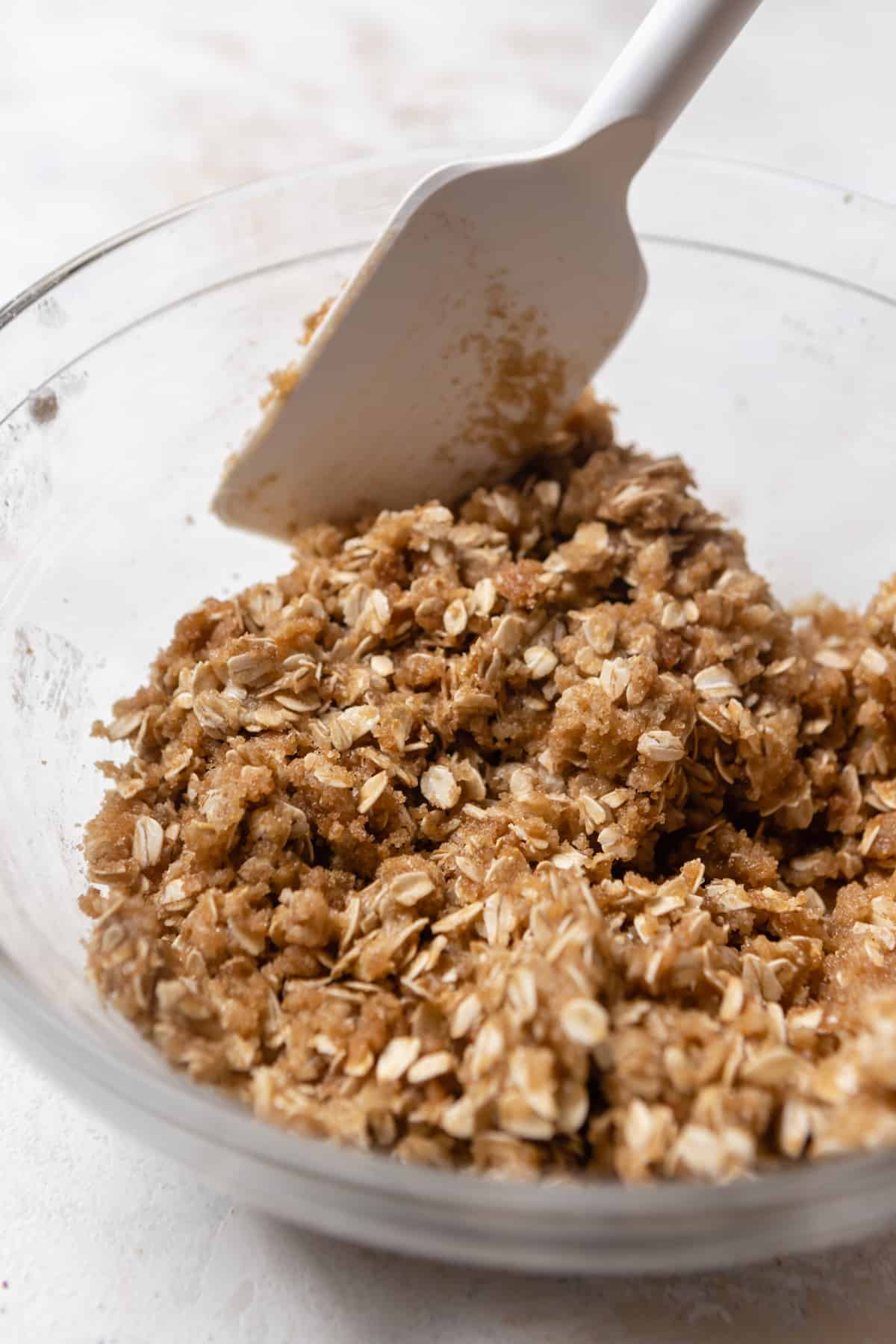 A crumble topping with oats being mixed in a bowl.