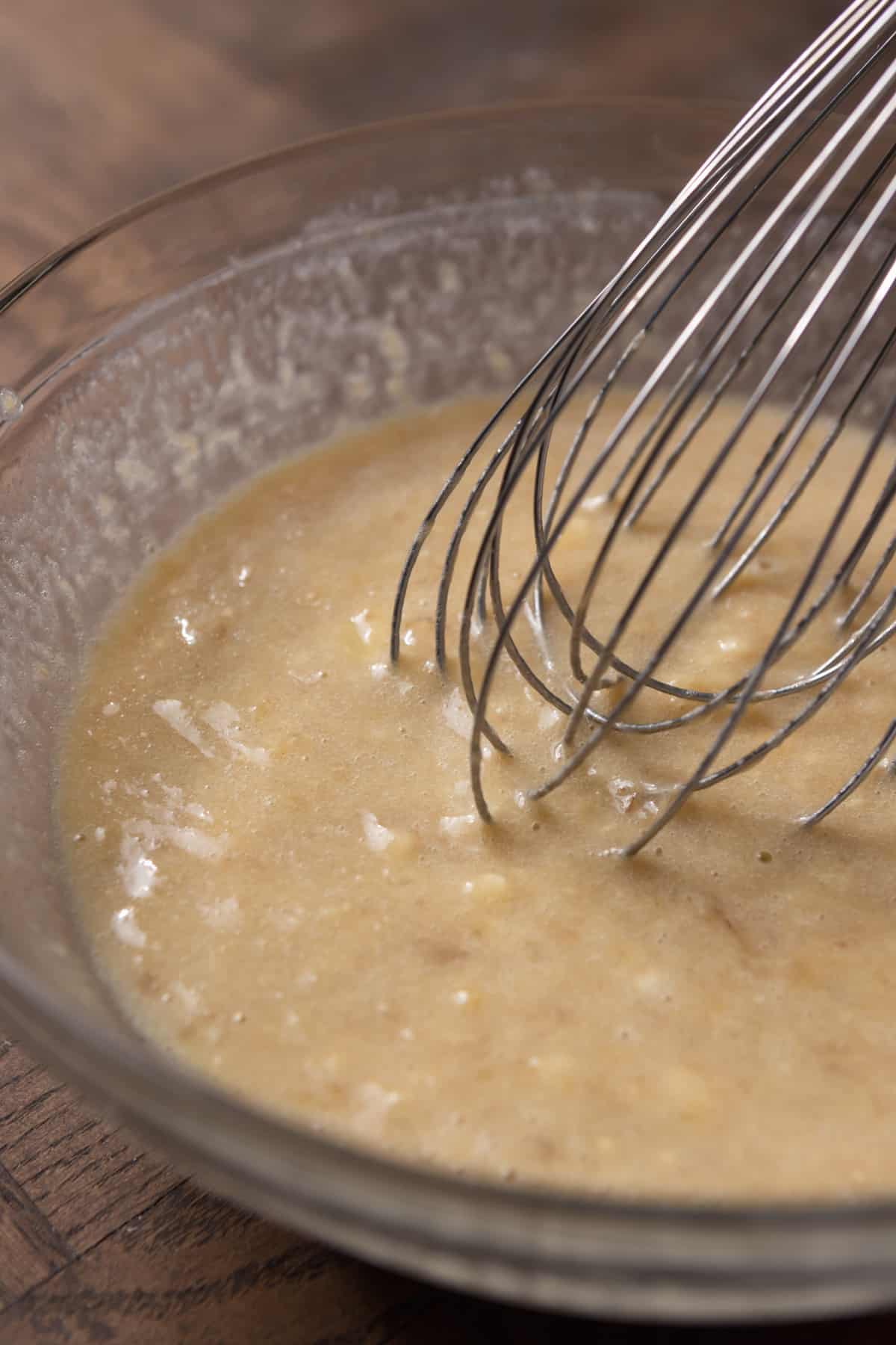 Wet ingredients being whisked in a bowl.