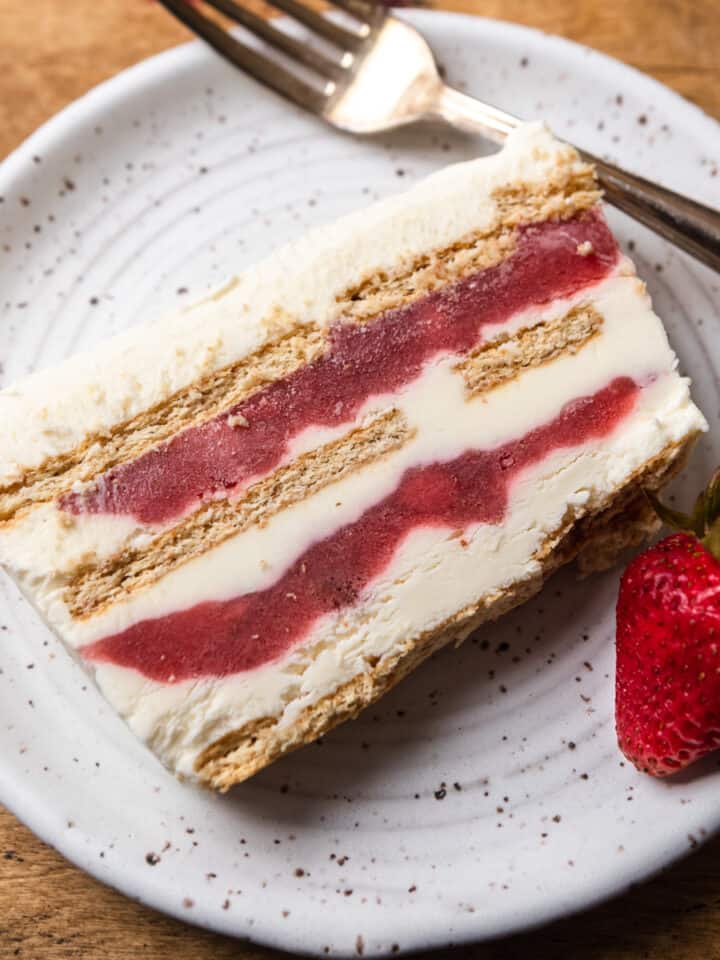 A slice of strawberry cream cheese icebox cake on a white plate.
