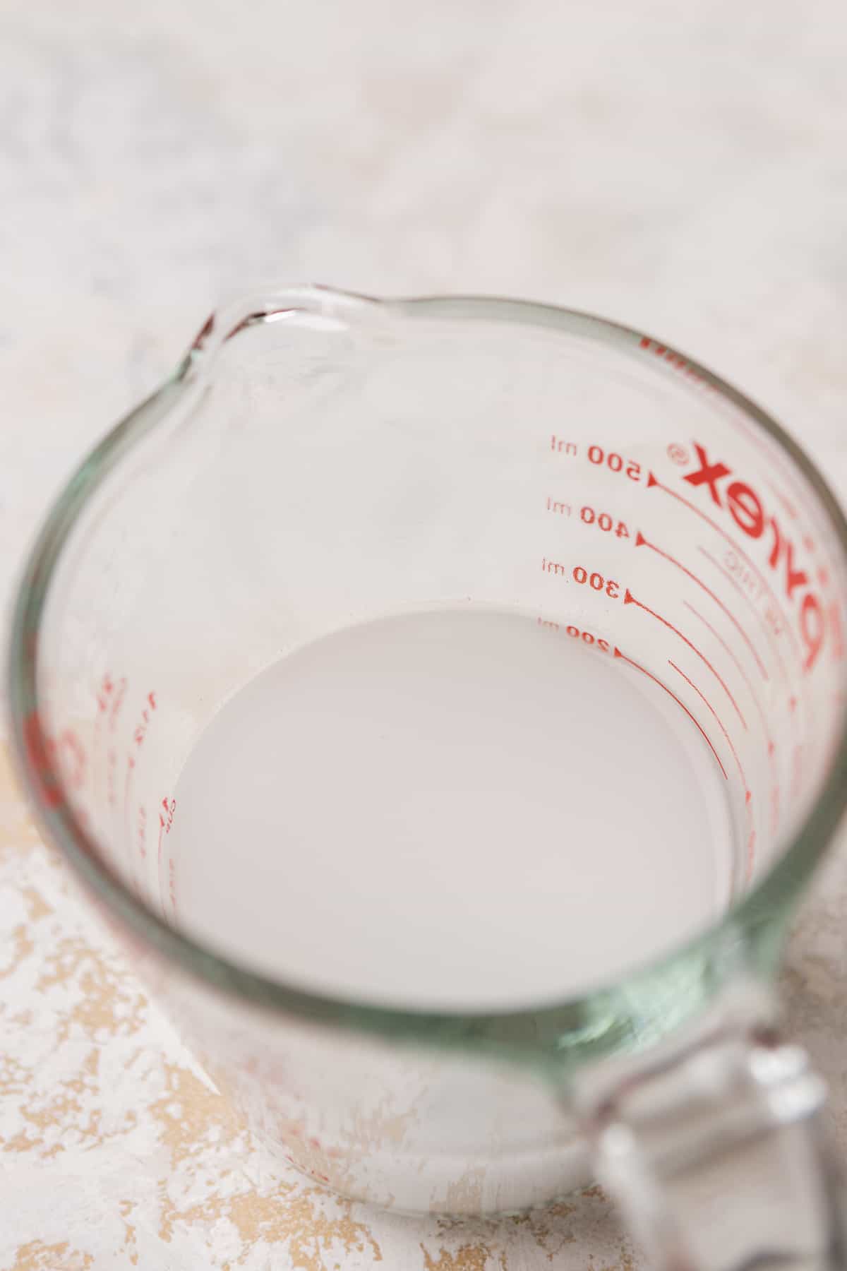 Water and cornstarch mixed together in a measuring cup.