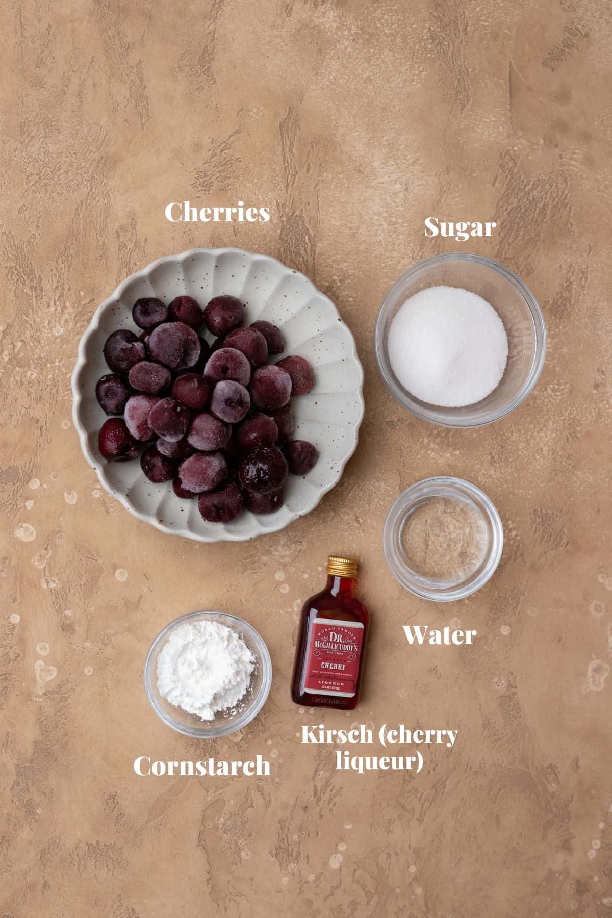 Ingredients to make cherry cake filling on a tan surface.