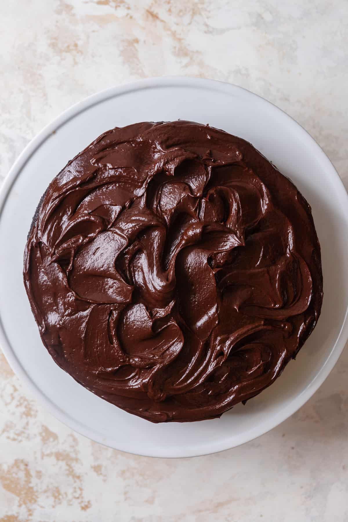 A cake on a white surface with ganache swirls.