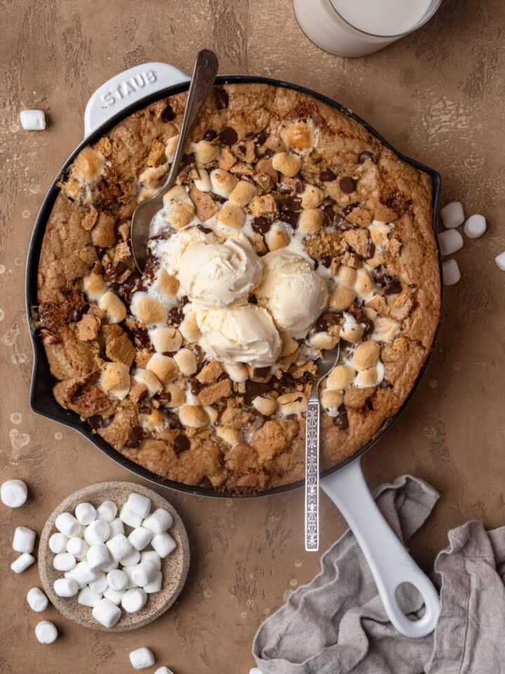 A smores skillet cookie topped with vanilla ice cream.