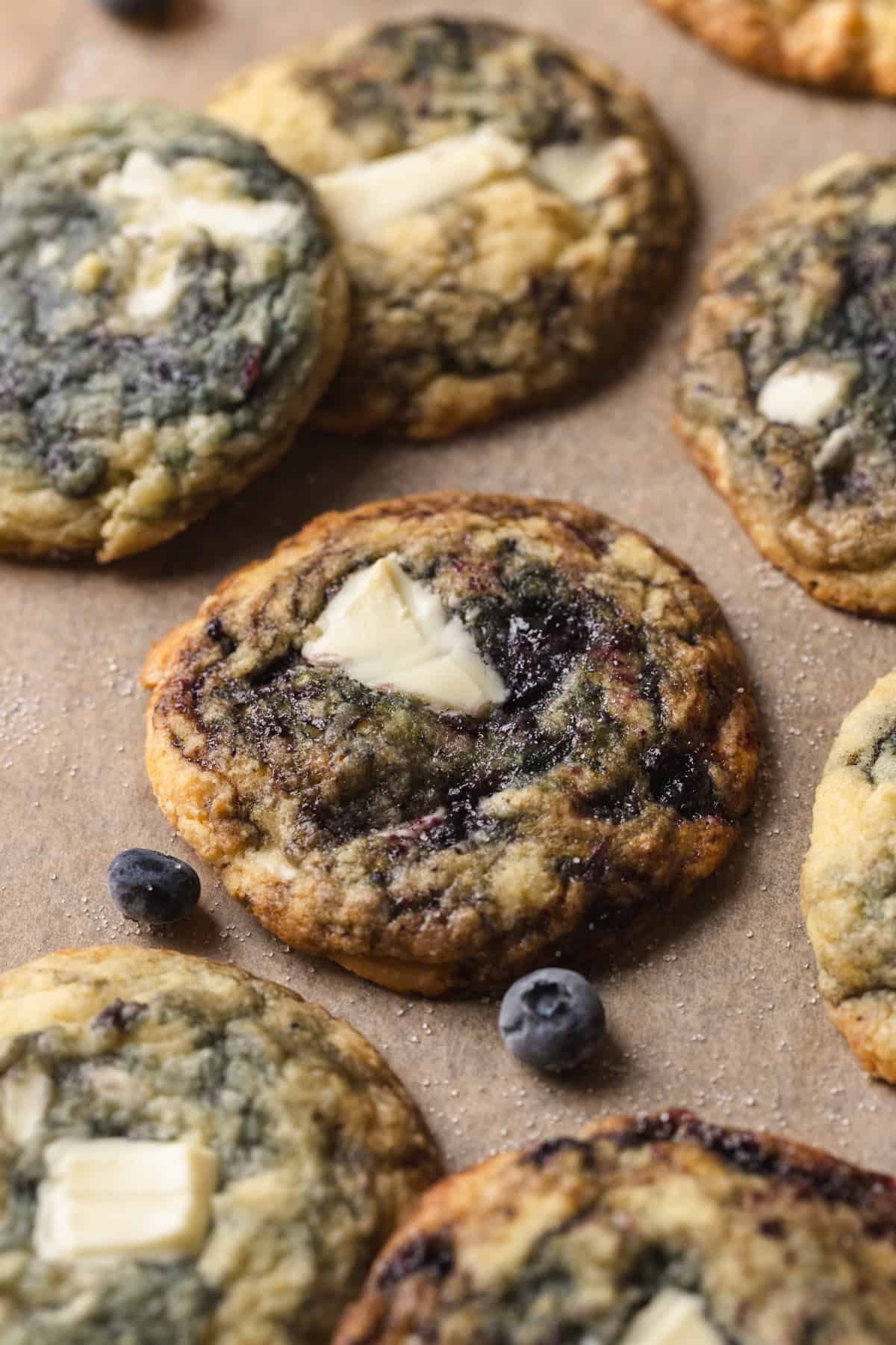 White chocolate blueberry cookies on brown parchment paper.
