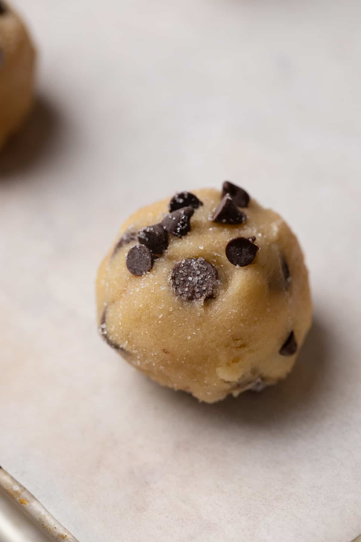 A cookie dough ball on a baking sheet.