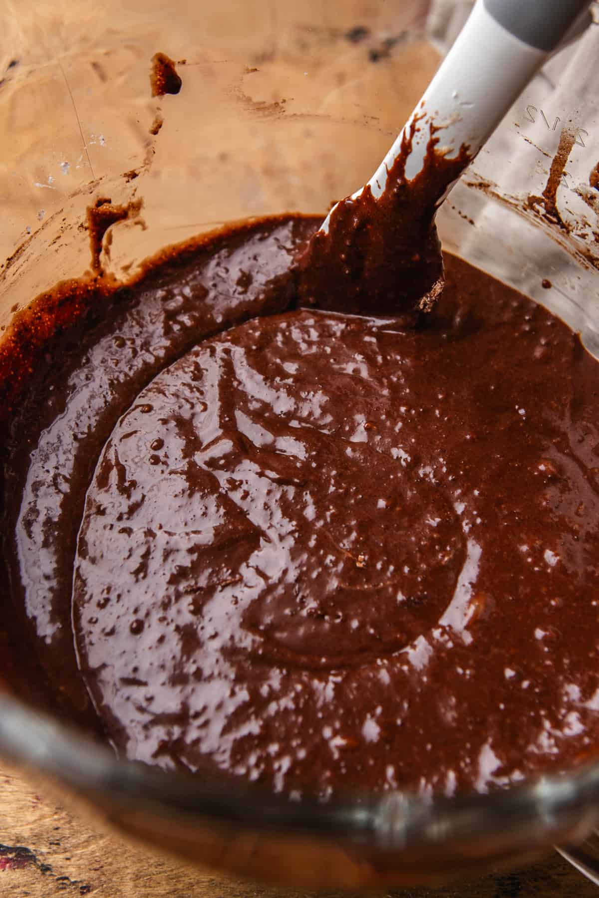Mixing wet ingredients to make chocolate cake batter in a bowl.
