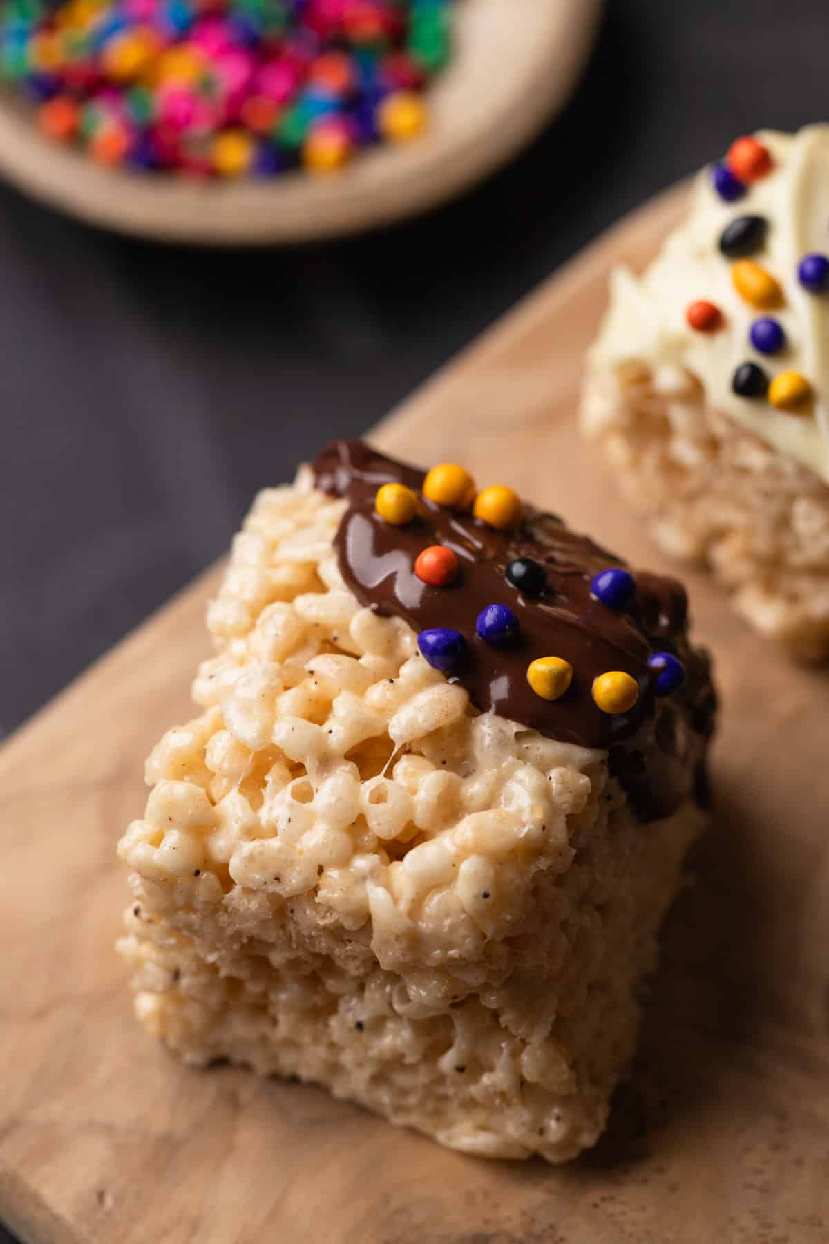 Close up of a Rice Krispie treat with chocolate and sprinkles.
