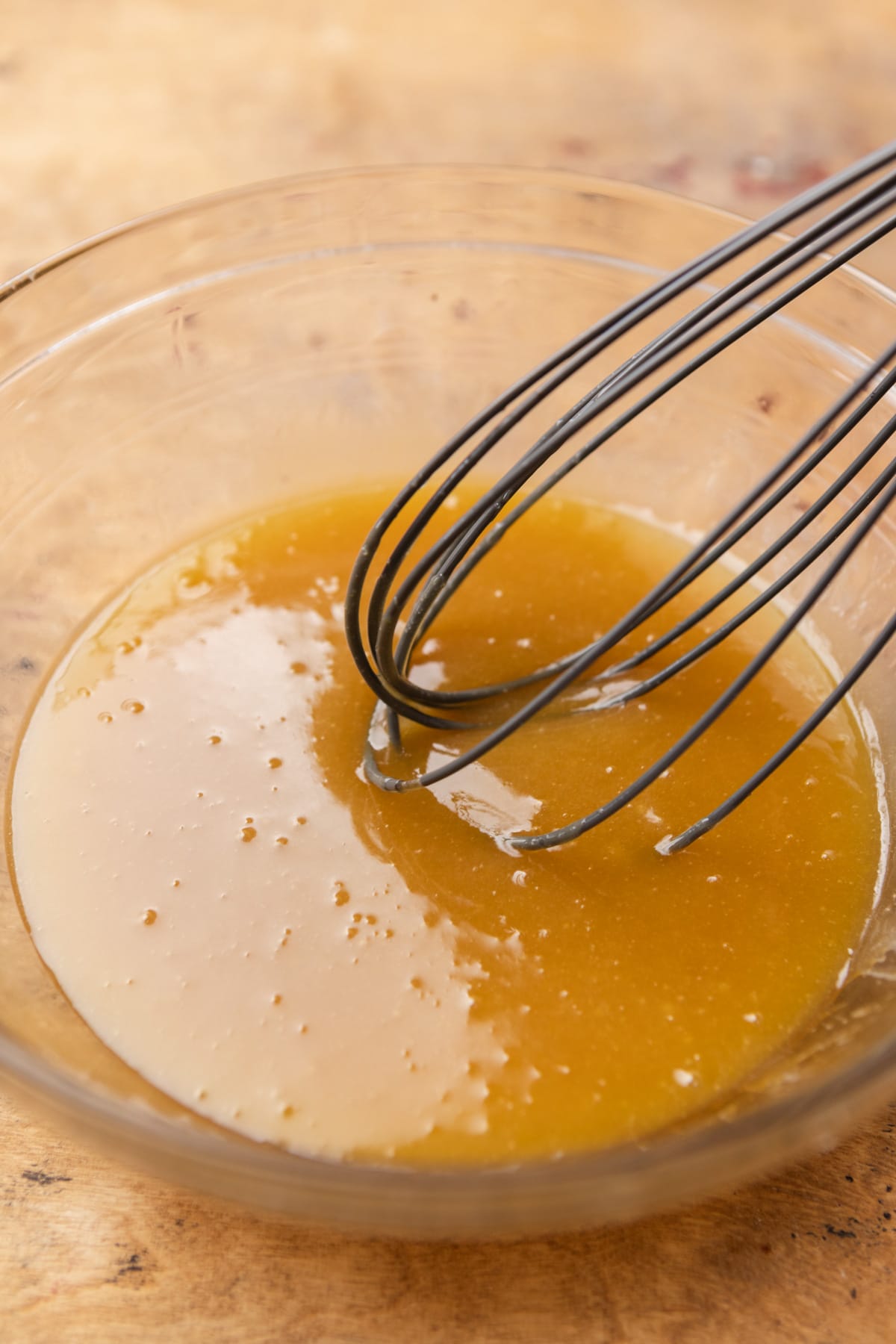 Sugars and eggs being whisked together in a bowl.