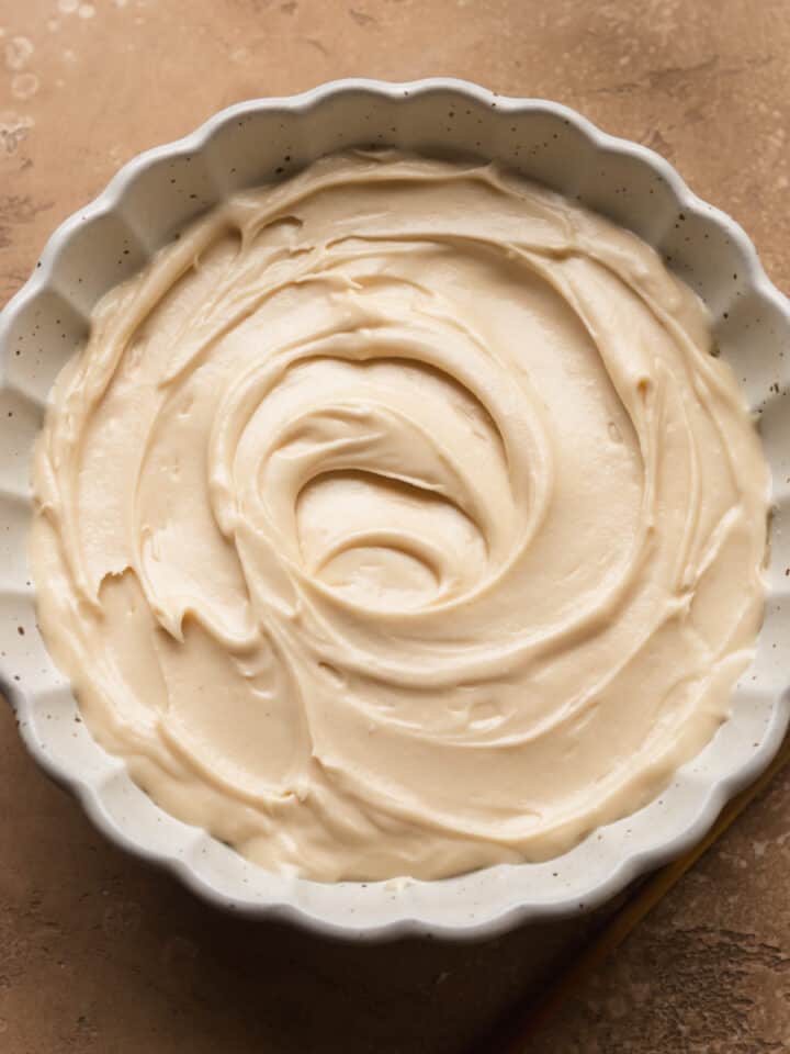 A bowl filled with coffee cream cheese frosting.
