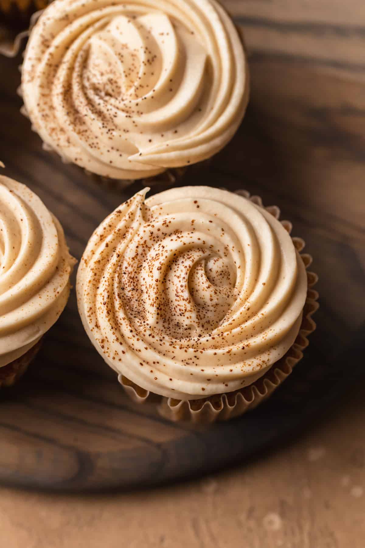 Coffee flavored cupcakes on a round wood board.