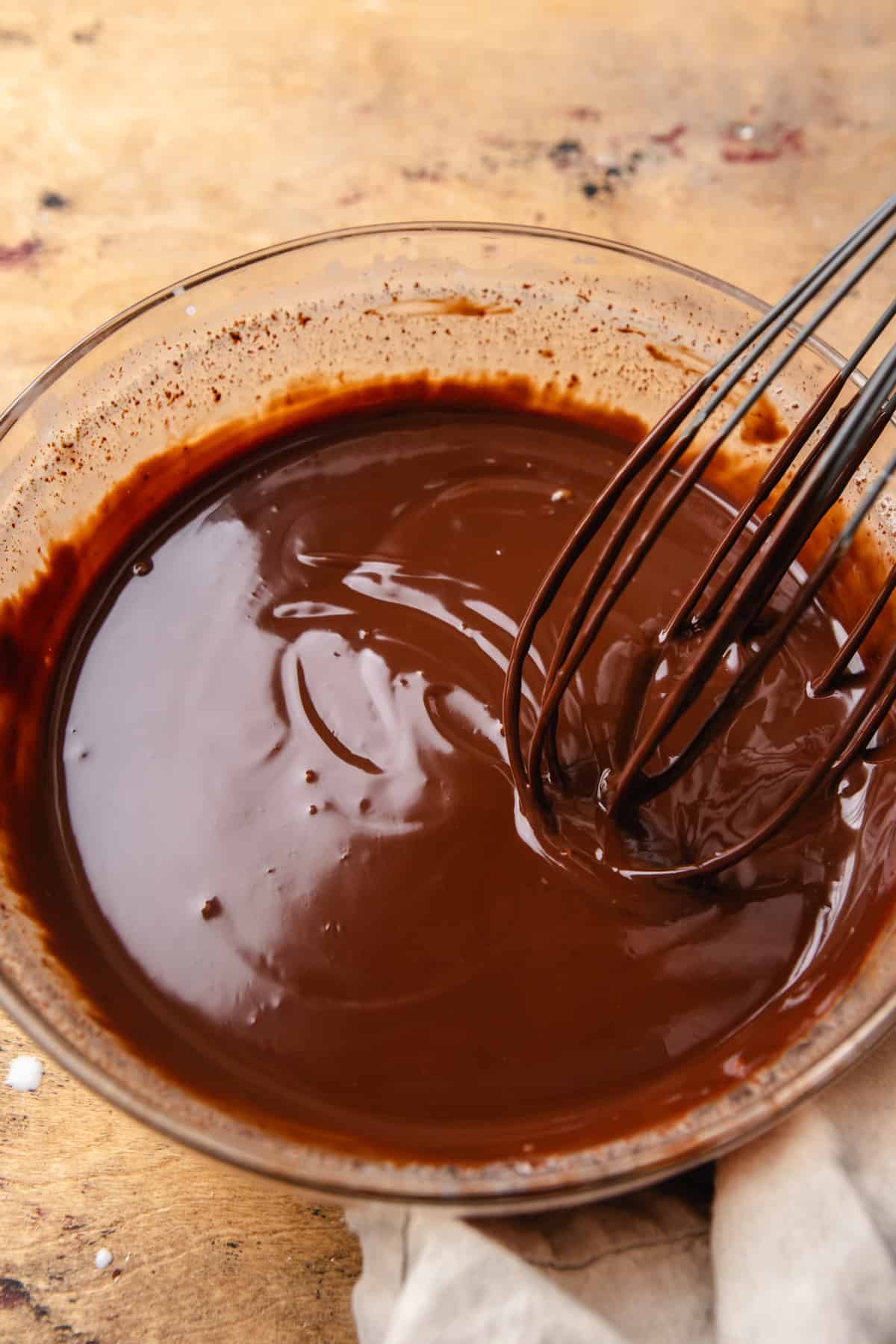 Melted chocolate in a bowl with a whisk.