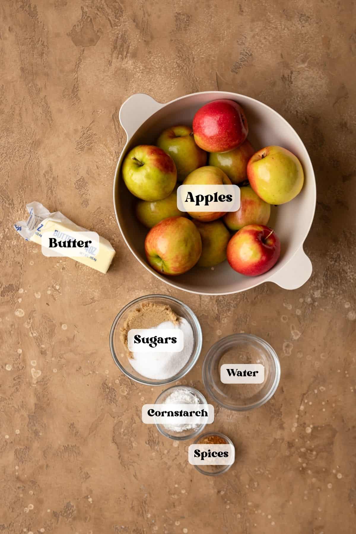 Ingredients to make apple filling on a brown surface.