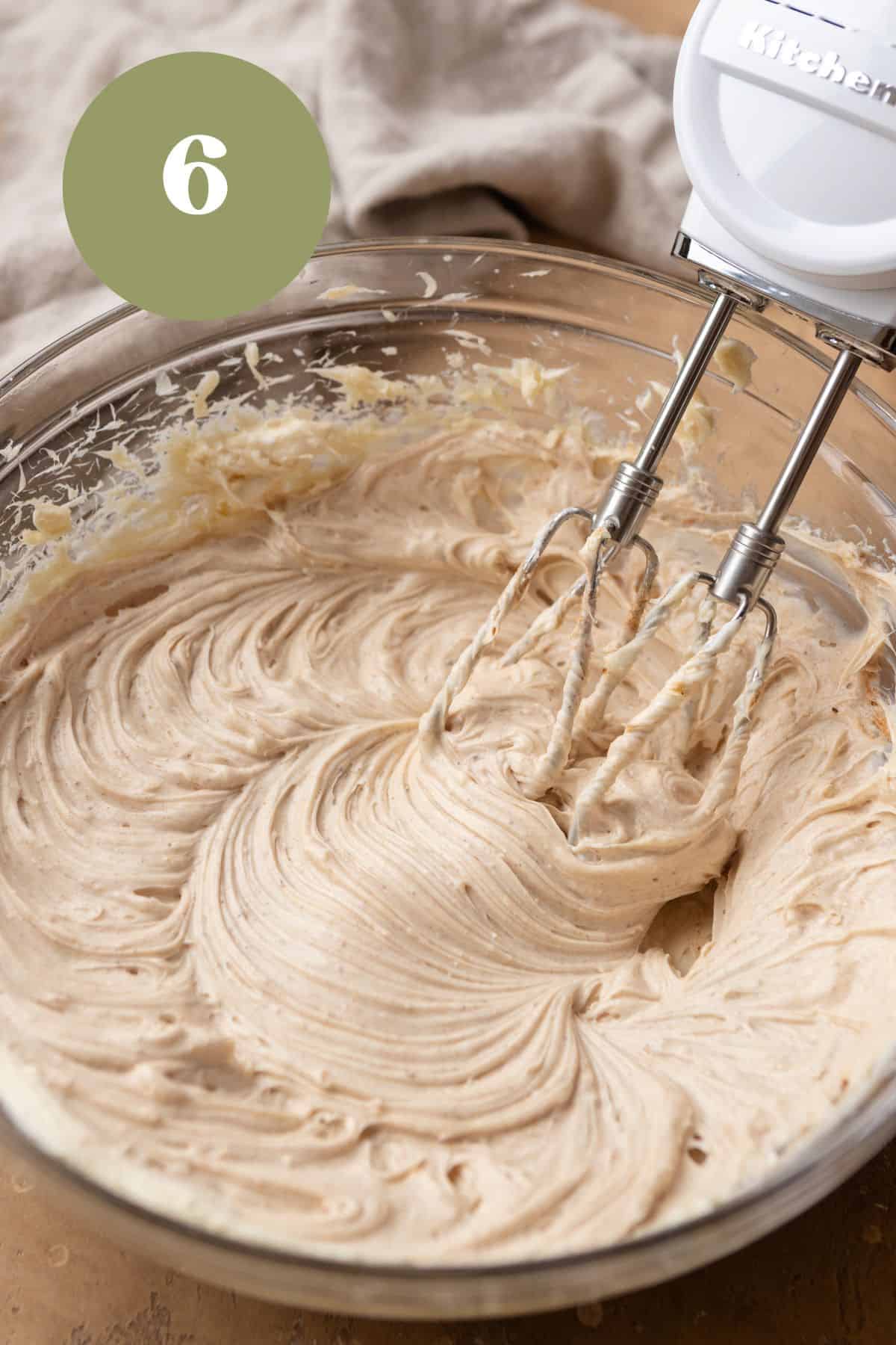 Cream cheese and spices being mixed in a large bowl.