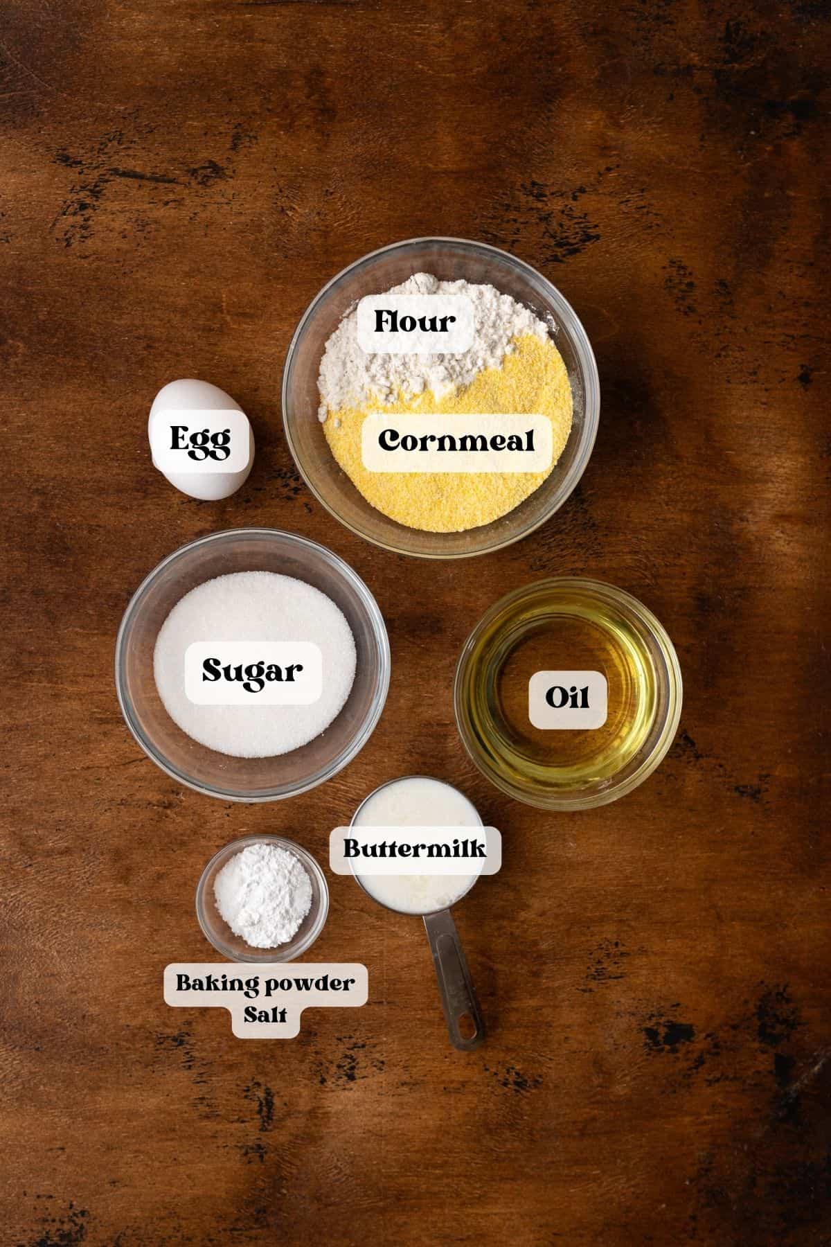 Ingredients to make cornbread donuts on a wood surface.