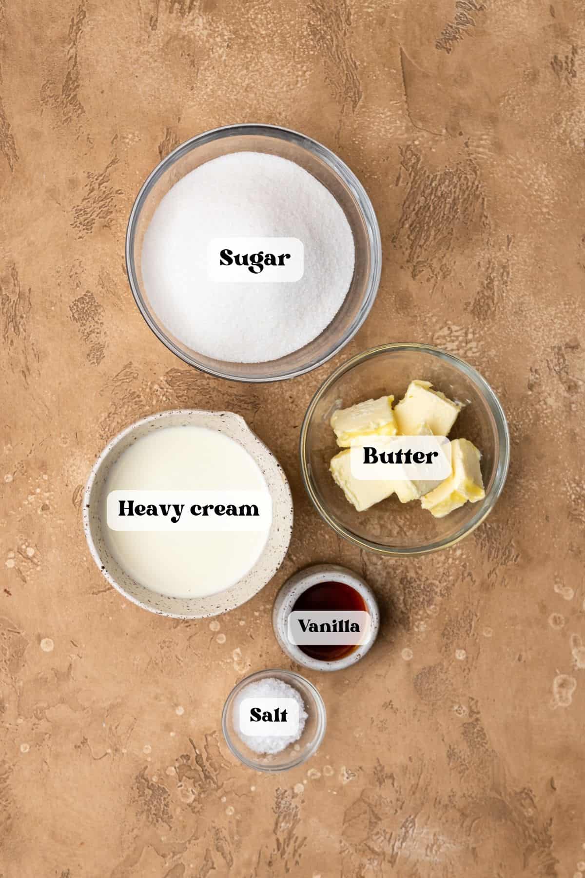 Ingredients to make salted caramel on a beige surface.