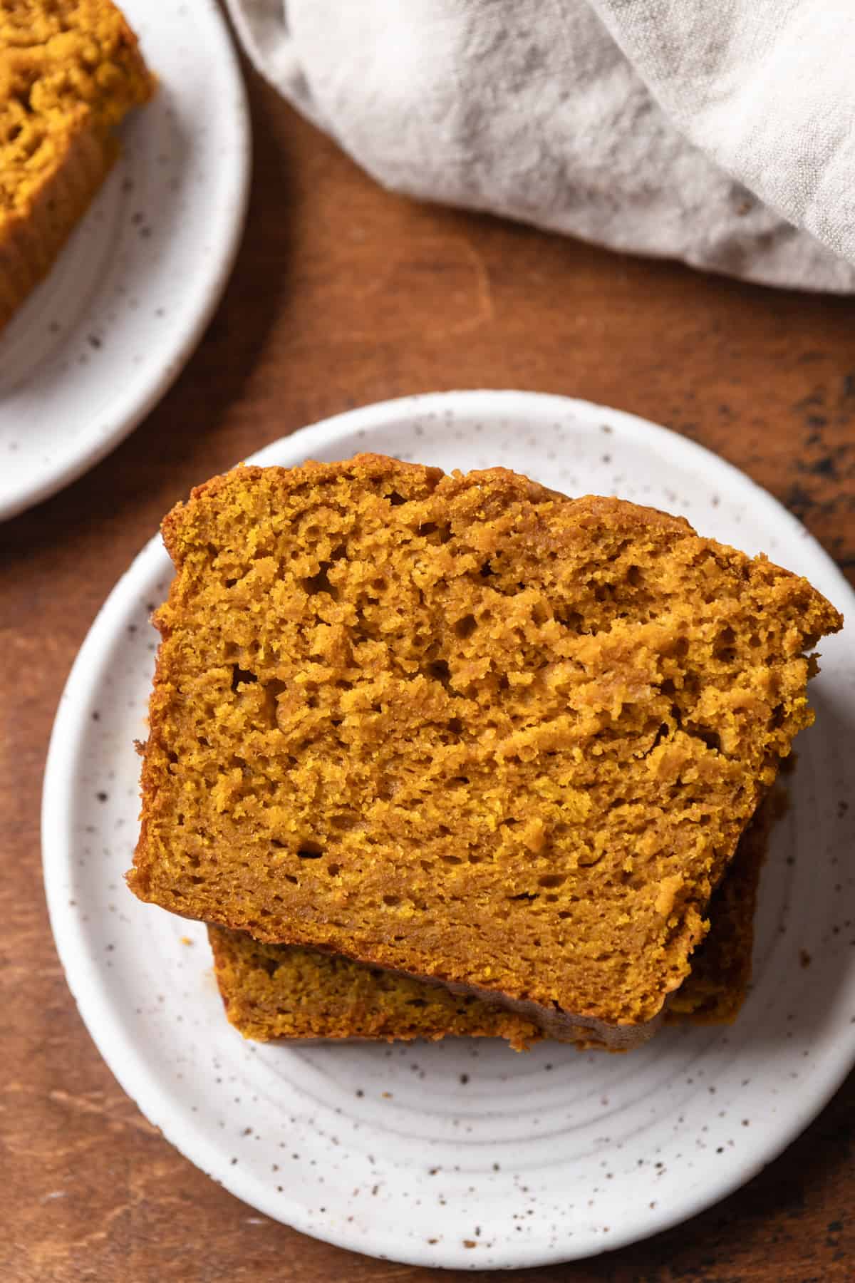 Slices of sour cream pumpkin bread on a white plate.