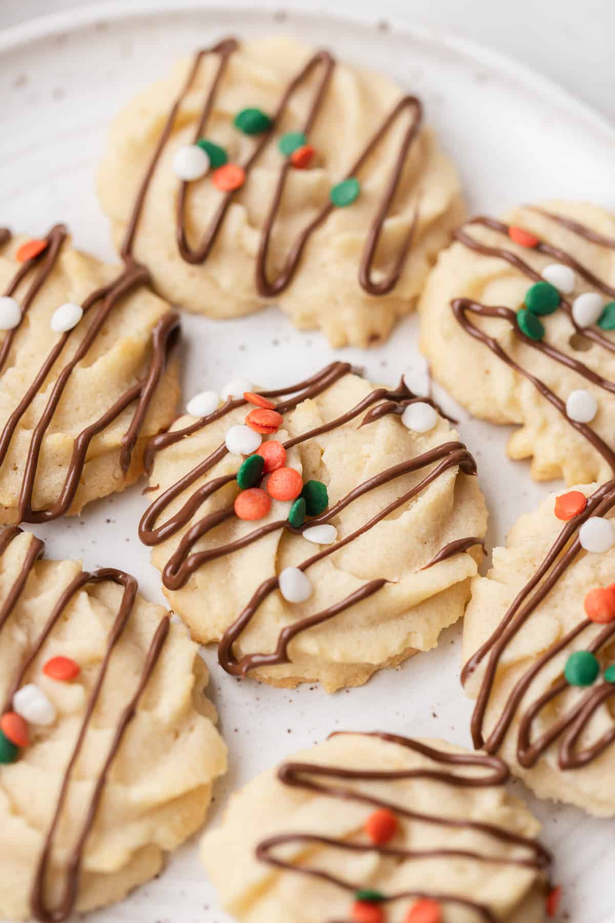 Danish butter cookies with Christmas sprinkles and chocolate drizzle.