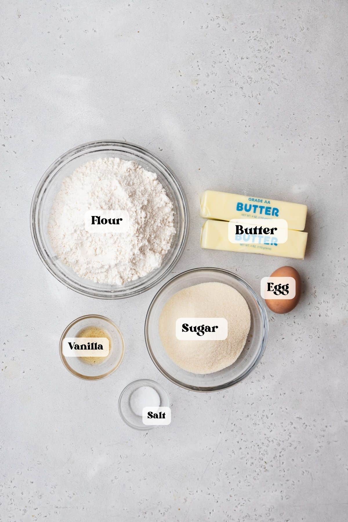 Ingredients to make danish butter cookies on a white surface.