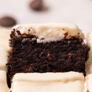 Close up of brownies with cream cheese frosting to show texture.